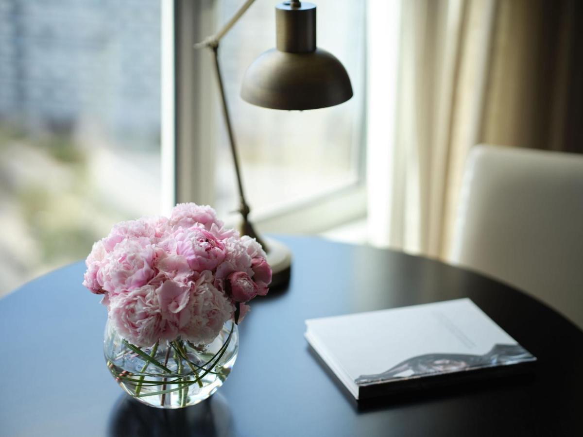 Corinthia Lisbon Hotel Exterior photo A table with a lamp, a book and a flower vase